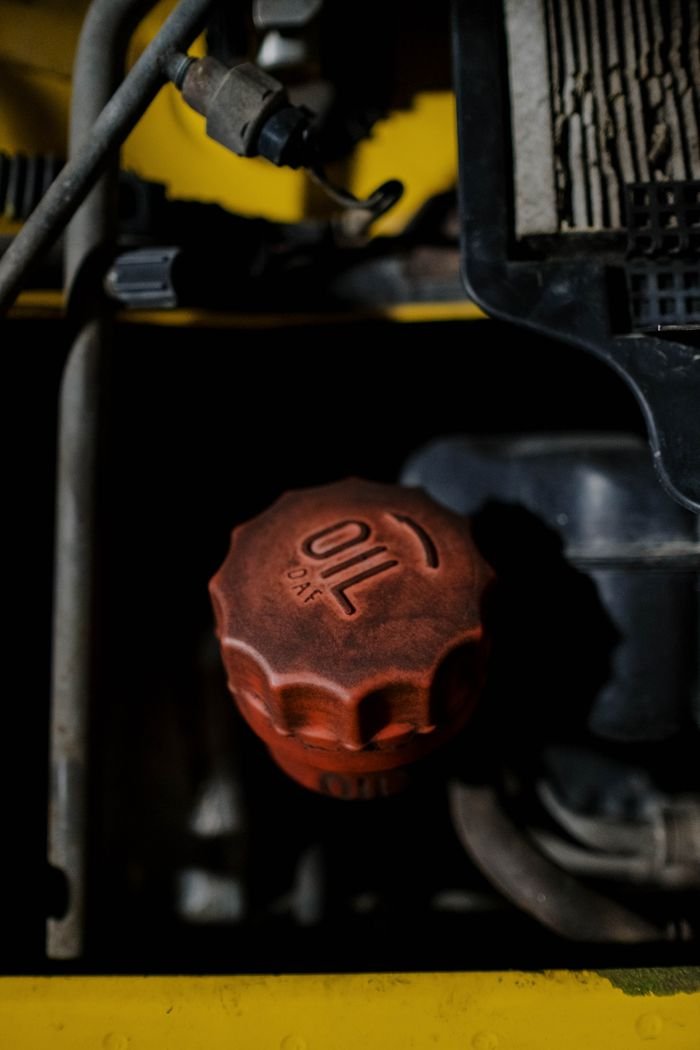 About Detailed view of a red oil cap on machinery, emphasizing industrial design.